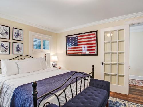 Un dormitorio con una cama y una bandera americana en la pared en Gordon Gem, en Savannah