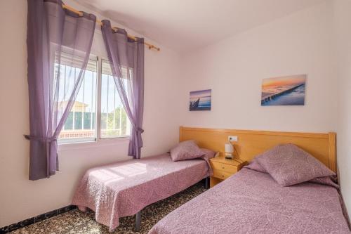 deux lits dans une chambre avec une fenêtre dans l'établissement Can Quetu, à Vinaròs