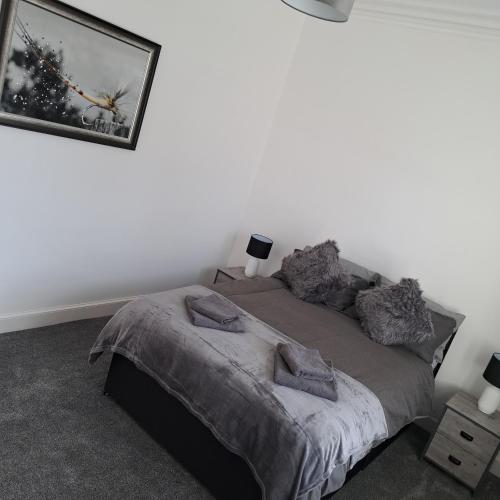 a bedroom with a bed and a picture on the wall at Maze 21one Apartment in Ayr