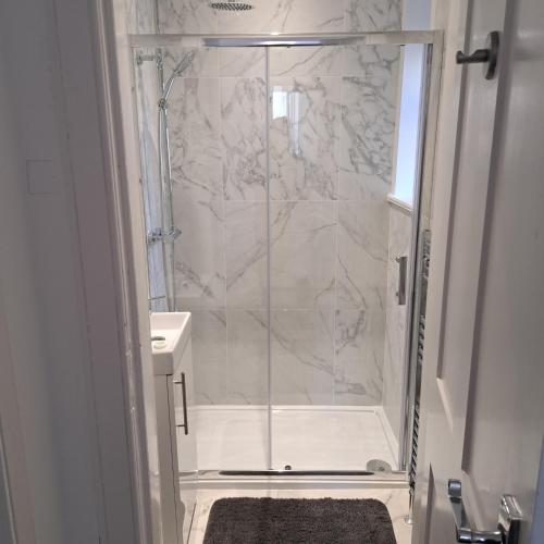 a shower with a glass door in a bathroom at Maze 21one Apartment in Ayr