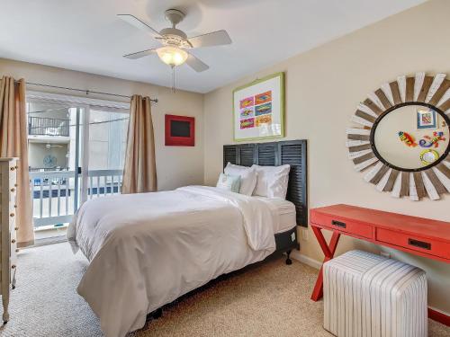 1 dormitorio con cama, espejo y ventana en Silver Sands en Tybee Island