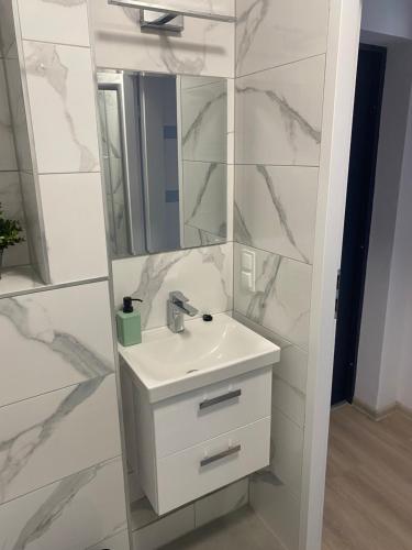 a white bathroom with a sink and a mirror at Mega widok 4 in Szklarska Poręba
