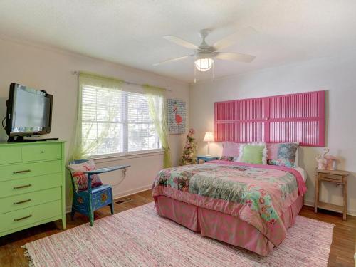 Schlafzimmer mit einem Bett und einem Flachbild-TV in der Unterkunft Barefoot Children in Tybee Island