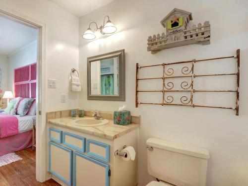 a bathroom with a sink and a toilet and a bed at Barefoot Children in Tybee Island