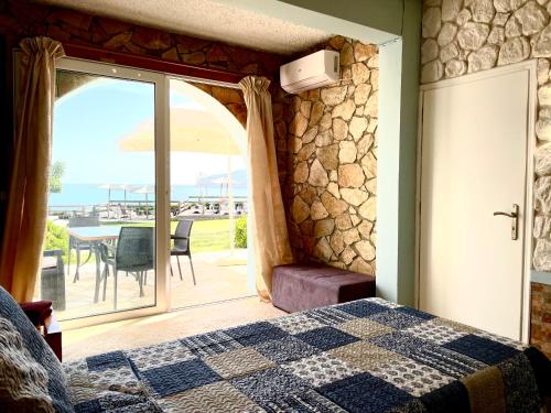 a bedroom with a bed and a view of the ocean at Hamre Apartments (Nicholas) in Agios Georgios Pagon