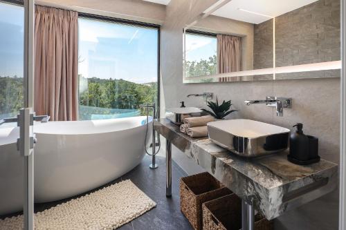 a bathroom with a large tub and a large window at Luxury Villa Cloer, Jadranovo - Sauna,Steam room, 2 Jacuzzis in Jadranovo