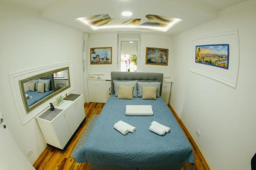 ein kleines Schlafzimmer mit einem blauen Bett mit zwei Kissen in der Unterkunft Pahuljica in Čačak