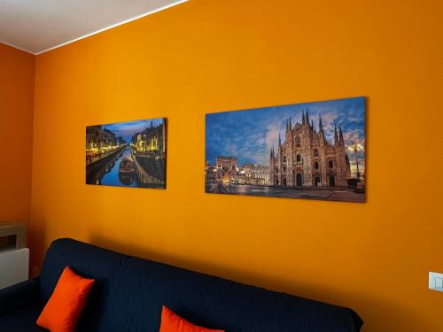 three pictures on a yellow wall with a blue couch at The Bright Place: wide and modern condo apartment in Milan in Milan