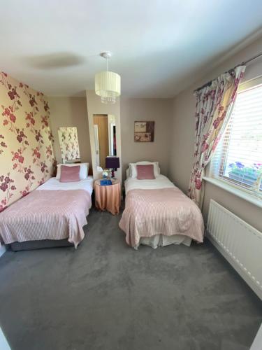 a bedroom with two beds and a window at Summer Cottage in Kinsale Free Car Parking Included in Kinsale