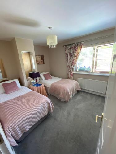 1 dormitorio con 2 camas y ventana en Summer Cottage in Kinsale, en Kinsale