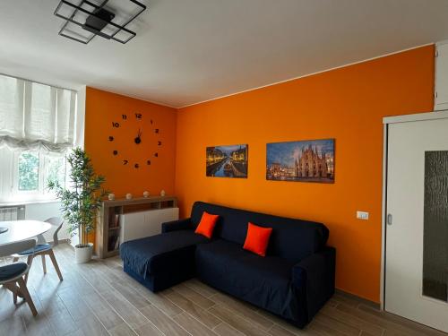 米蘭的住宿－The Bright Place: wide and modern condo apartment in Milan，客厅设有蓝色的沙发和橙色的墙壁