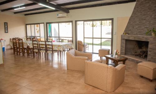 ein Wohnzimmer mit einem Kamin, einem Tisch und Stühlen in der Unterkunft Alojamiento Turístico Pelucho Sillero in Junín