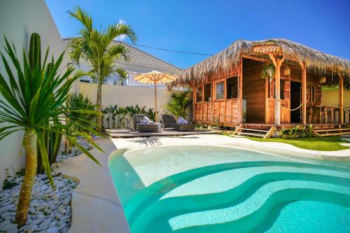 a resort with a pool and a house at Villa Motu Bingin in Uluwatu