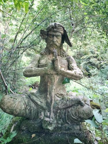 a statue of a woman sitting on a log at D'kailash Retreat in Singaraja