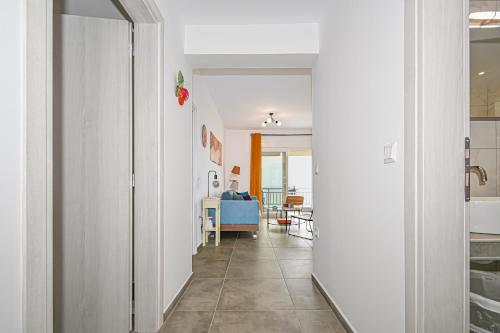 pasillo que conduce a una sala de estar con sofá azul en E & D family apartment by the sea, en Kalivia Poligirou