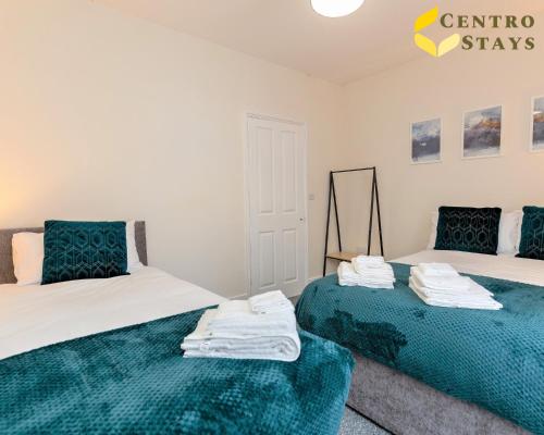 a bedroom with two beds with green and white sheets at 5-10percent Off Week Monthly Stays Families, Groups, Contractor, Relocation or Corporate Booking in Northampton