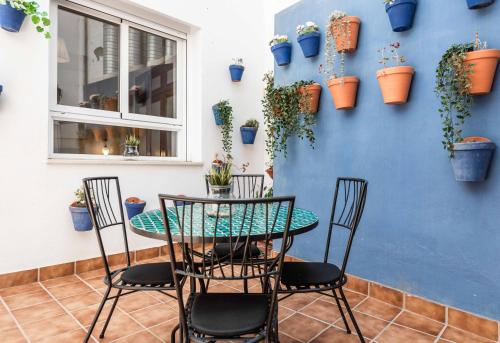 un patio con tavolo, sedie e piante in vaso di UrbanChicMalaga Historic Malaga Apt with Calm Private Patio a Málaga