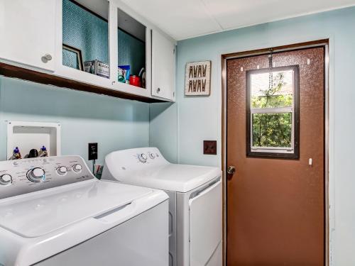 a laundry room with a washing machine and a window at Tybee Tree House in Tybee Island