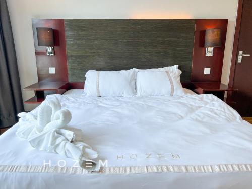 een wit bed met een handdoek erop bij SCSP 777 Premium 2BR2B Near Imago and KKIA in Kota Kinabalu