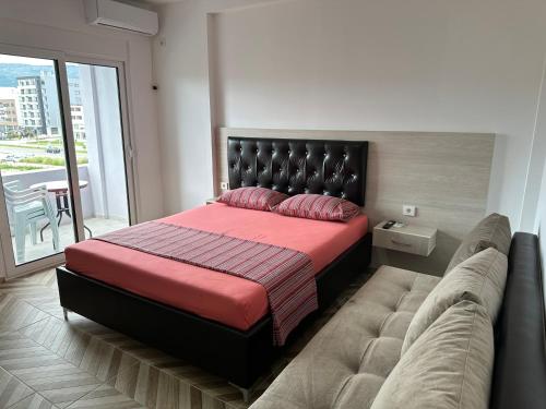 a bedroom with a large bed and a couch at Apartments Flamida in Ulcinj