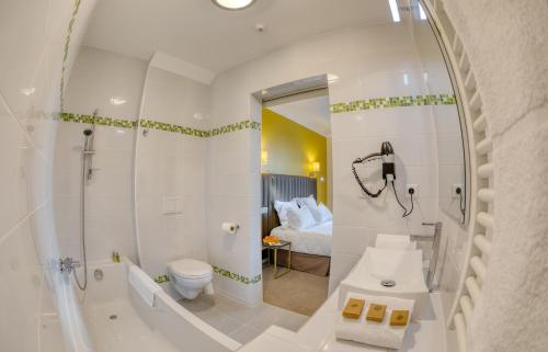 een badkamer met een douche, een toilet en een wastafel bij Hôtel L'Orée des plages in Clohars-Carnoët