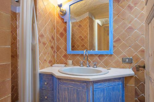 un baño con lavabo y espejo en Paradiso sul Pevero, en Porto Cervo