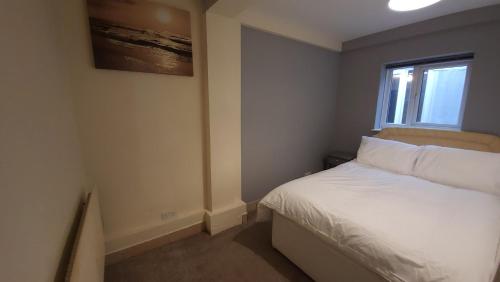 a small bedroom with a bed and a window at Fully Furnished 3 bedroom Appartment in Bristol