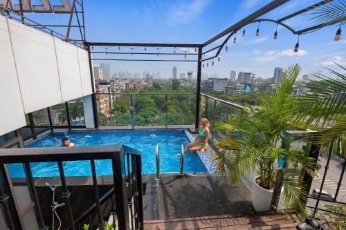 a man and a woman in a swimming pool on a building at 22Land Residence Hotel & Spa Ha Noi in Hanoi