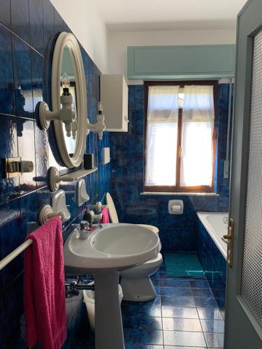 een badkamer met een wastafel, een toilet en een spiegel bij B&B Casa Gaia in Meano