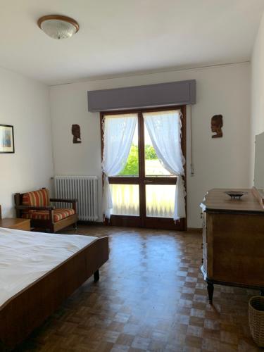 een slaapkamer met een bed en een groot raam bij B&B Casa Gaia in Meano