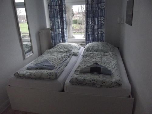 2 camas en una habitación pequeña con ventana en " Ferienhaus Vadersdorf" Wohnung 3, en Vadersdorf