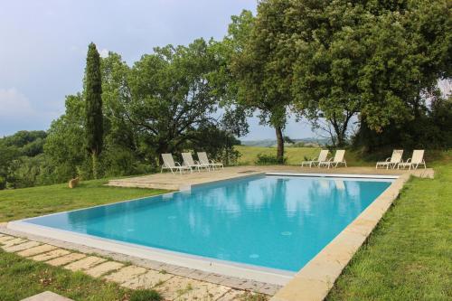 uma piscina num quintal com cadeiras e árvores em Agriturismo Quarantallina em Buonconvento