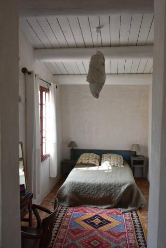 une chambre avec un lit et un tapis au sol dans l'établissement La petite maison des artistes, à Séguret