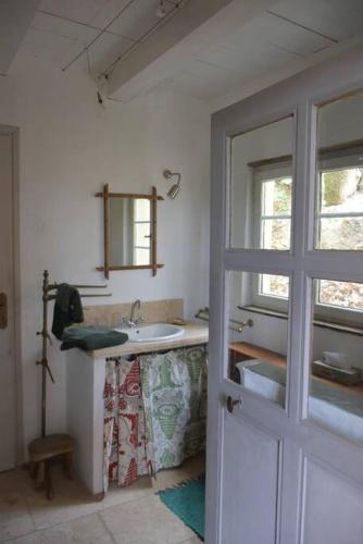 une salle de bain blanche avec un lavabo et une fenêtre dans l'établissement La petite maison des artistes, à Séguret