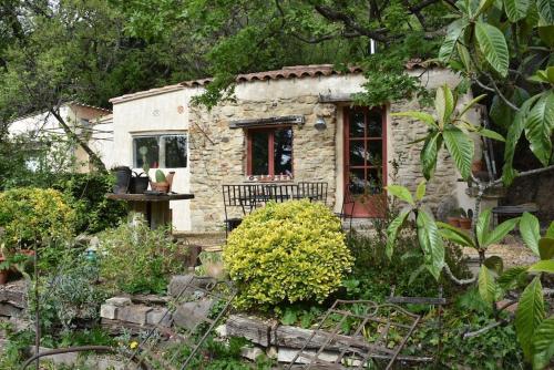 a small stone house in the middle of a garden at La petite maison des artistes in Séguret