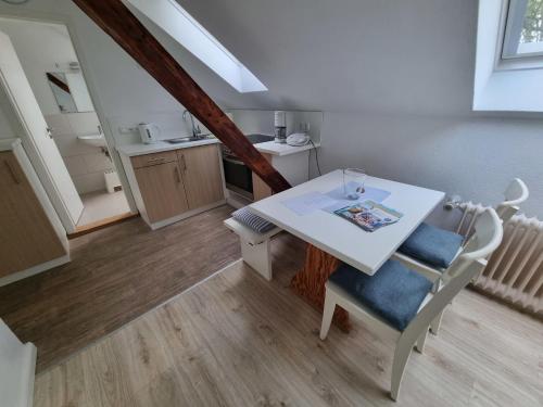 una mesa blanca y sillas en una habitación con cocina en " Ferienhaus Vadersdorf" Wohnung 3, en Vadersdorf