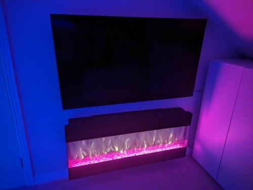 a room with a fireplace with purple and pink lights at New House, Private Rooms in a Peaceful Neighborhood in Dublin