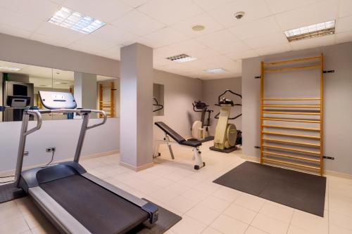 a gym with a treadmill and ellipticals in a room at Iberik Santo Domingo Plaza Hotel in Oviedo