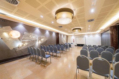 a conference room with chairs and a whiteboard in it at Iberik Santo Domingo Plaza Hotel in Oviedo