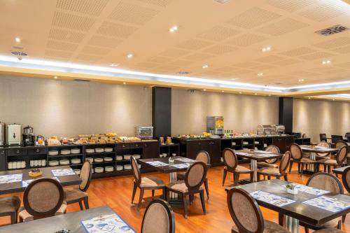 a restaurant with tables and chairs in a room at Iberik Santo Domingo Plaza Hotel in Oviedo