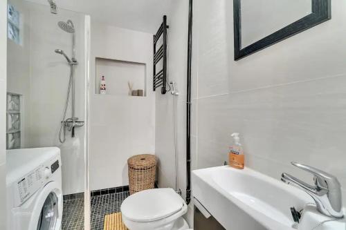 Baño blanco con aseo y lavamanos en Casa Castillo. en Denia