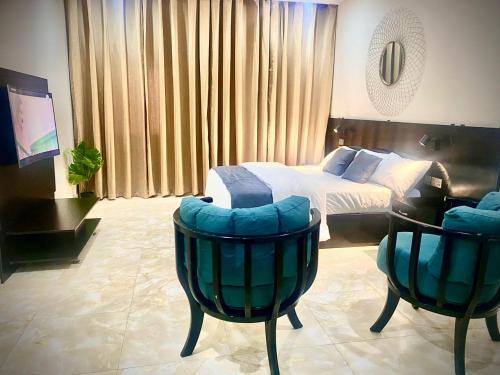 a hotel room with a bed and two chairs at Abi's Place in Tungan Ali