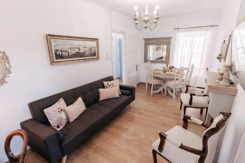 a living room with a black couch and a dining room at Elia House 2 near Nafpaktos in Lóngos