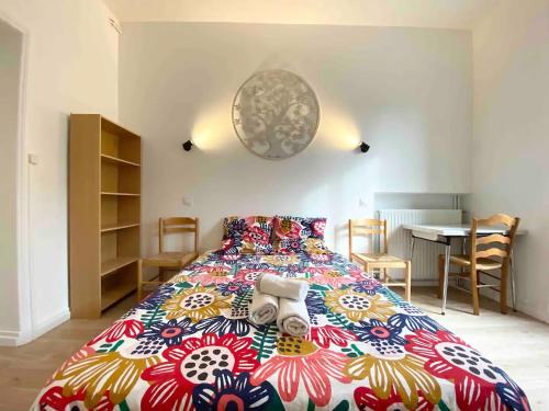 une chambre avec un grand lit avec une couverture colorée dans l'établissement LE DECO - Confort - Wifi - Luminosité - Entre gare et Centre, à Quimper