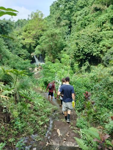 a group of people walking down a dirt trail at D'kailash Retreat in Singaraja