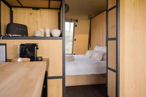 um pequeno quarto com uma cama numa pequena casa em Vakantie plezier Vlaanderen em Zedelgem