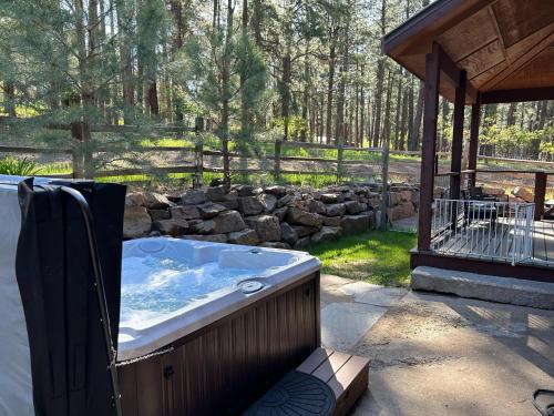 a hot tub on a patio with a stone wall at 984 Pine Valley Forest Lakes in Vallecito