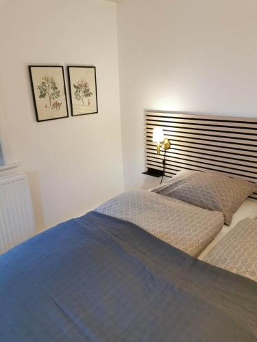 a bedroom with a bed and two pictures on the wall at Agervig Bed & Breakfast in Næsbjerg