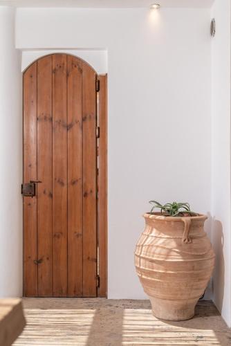 a vase sitting in front of a wooden door at Euphoria Suites and Spa in Kardamaina
