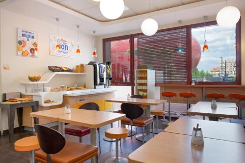 a fast food restaurant with tables and chairs at ibis budget Perpignan Centre Rénové en 2025 in Perpignan